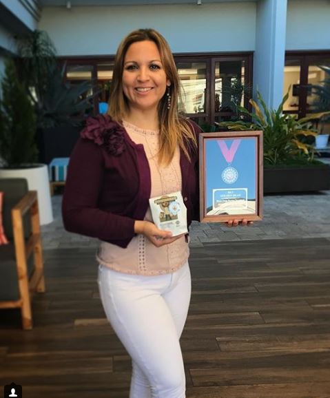 Anny Ruth with a clients award, won with Loma La Gloria coffee.
